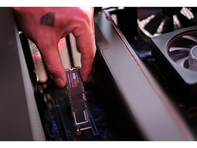 Un SSD Samsung 990 PRO nu en cours d'installation dans un ordinateur de bureau.